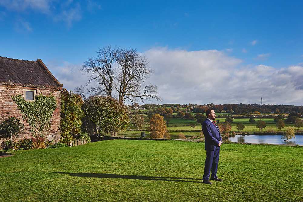 The groom waiting on the The Ashes front lawn for his bride - First look
