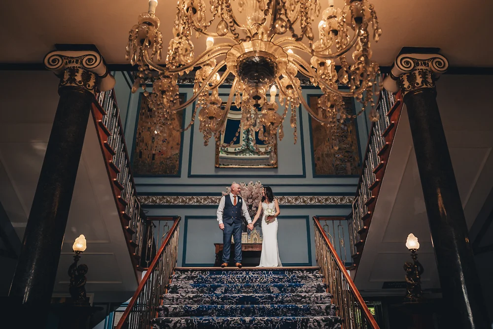 Shrigley Hall Macclesfield Wedding Photographer - Bride and groom on staircase