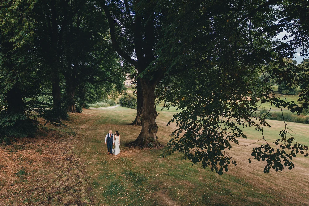 Shrigley Hall Macclesfield Wedding Photographer - Bride and groom walking through woods