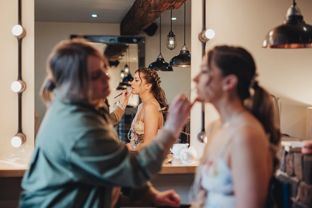 Bridesmaid having makeup applied at The Ashes Barns in Staffordshire