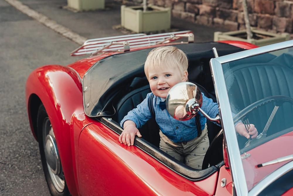 Little boy sat in MG sports car at The Ashes Barns Staffordshire