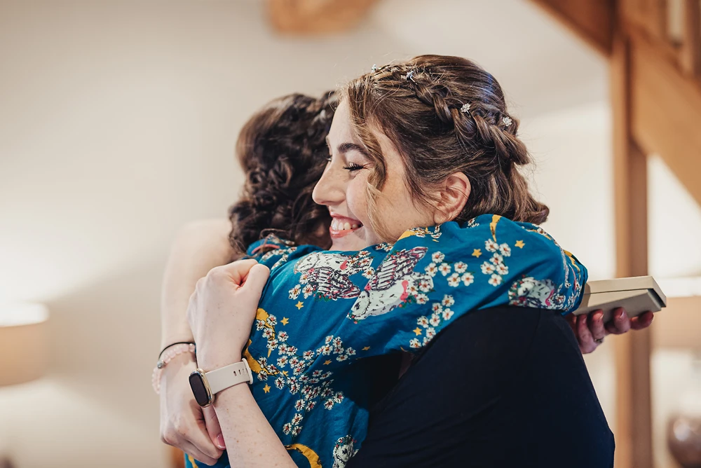 Bride hugs maid of honour at The Ashes Barns in Staffordshire